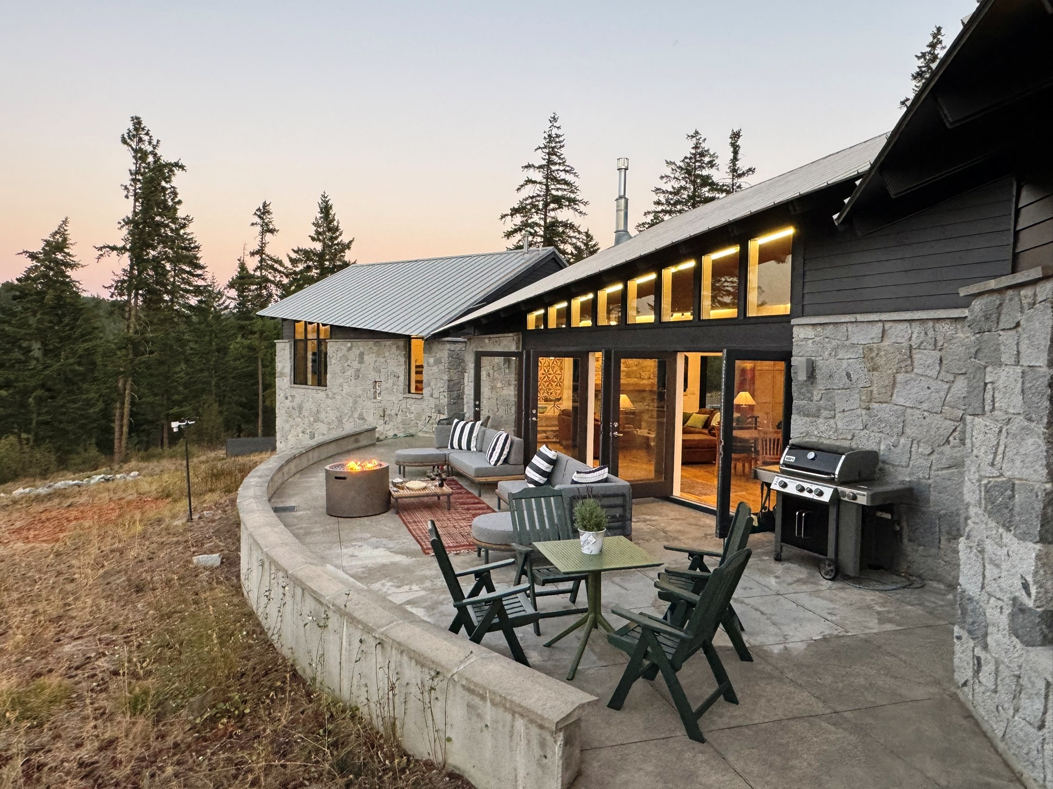 Curved stone patio with firepit at dusk